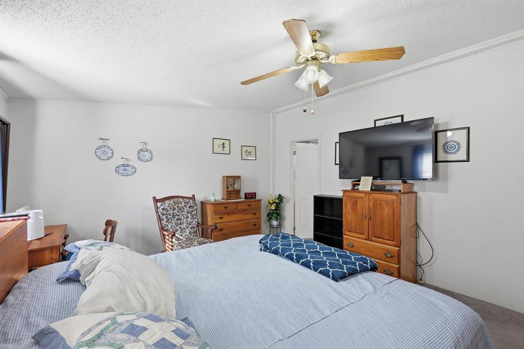 609 Cedar Mills Road Gordonville, TX 76245 - Photo 19 of 38 a bedroom with a bed and dresser with mirror