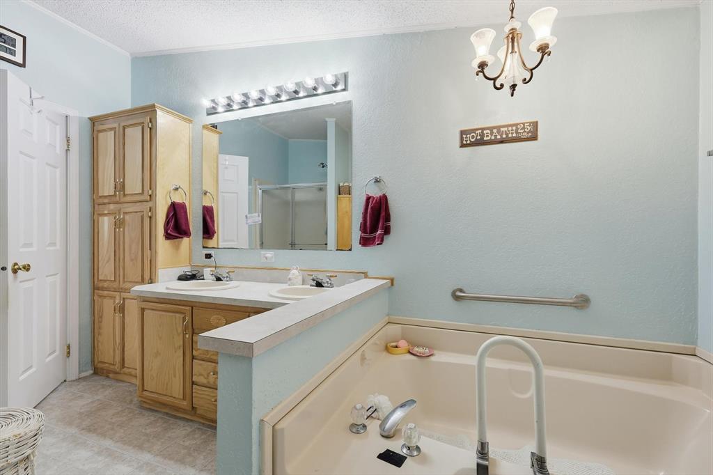 609 Cedar Mills Road Gordonville, TX 76245 - Photo 21 of 38 a bathroom with a tub sink and mirror