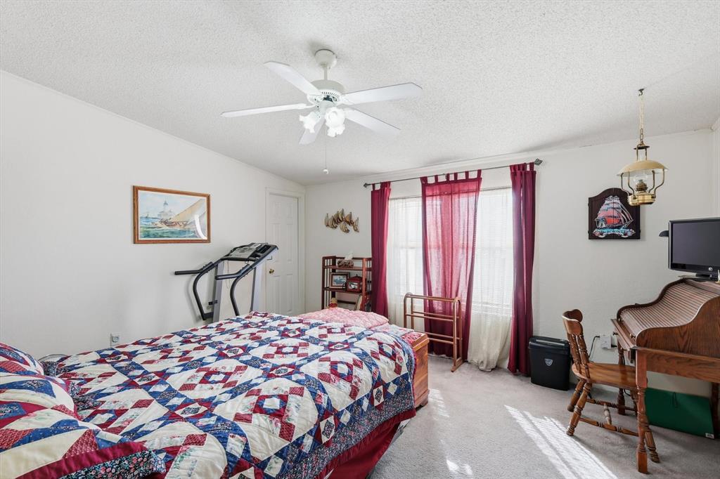 609 Cedar Mills Road Gordonville, TX 76245 - Photo 23 of 38 a bedroom with a bed and a chandelier