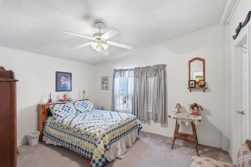609 Cedar Mills Road Gordonville, TX 76245 - Photo 26 of 38 a bedroom with a bed and a chandelier