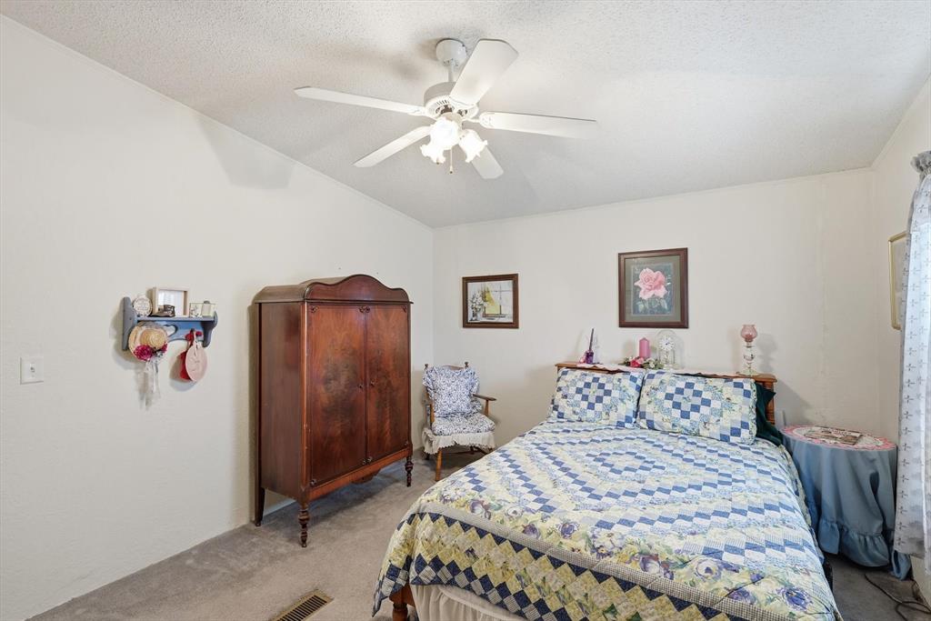 609 Cedar Mills Road Gordonville, TX 76245 - Photo 27 of 38 a bedroom with a bed and a chandelier