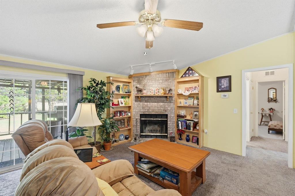 609 Cedar Mills Road Gordonville, TX 76245 - Photo 9 of 38 a living room with furniture a fireplace and a chandelier