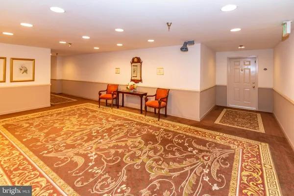 a view of a hallway with wooden floor and a rug