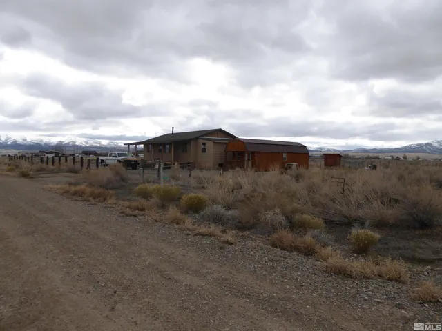 a view of a dry yard with wooden fence