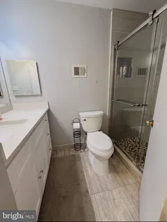 a bathroom with a sink a toilet and shower