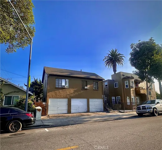 a front view of a building with cars parked