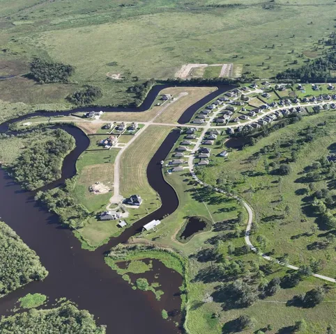 an aerial view of a residential house with a yard and green space