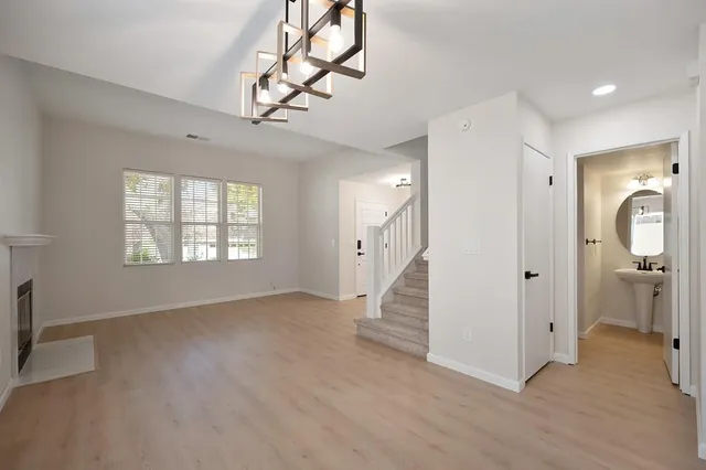 an empty room with wooden floor cabinet and windows