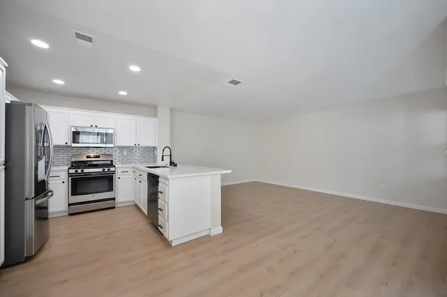a kitchen with stainless steel appliances a refrigerator and a stove top oven