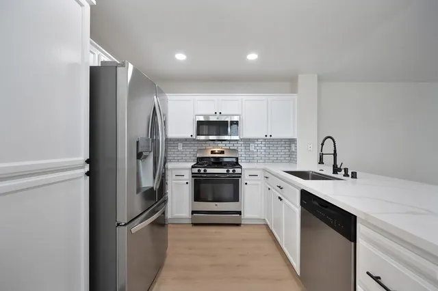 a kitchen with a sink and stainless steel appliances
