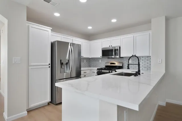 a kitchen with granite countertop a refrigerator and a sink