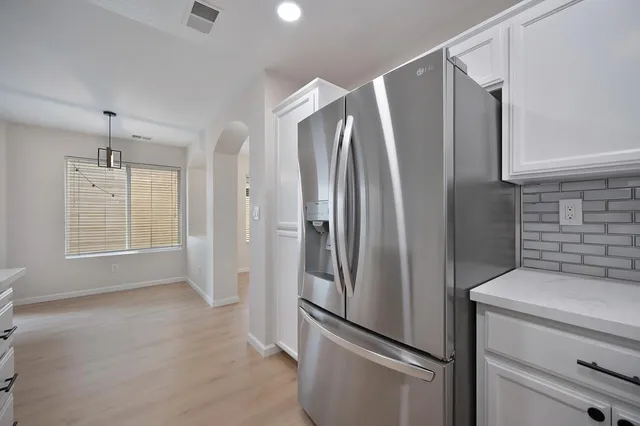 a metallic refrigerator freezer sitting in a kitchen