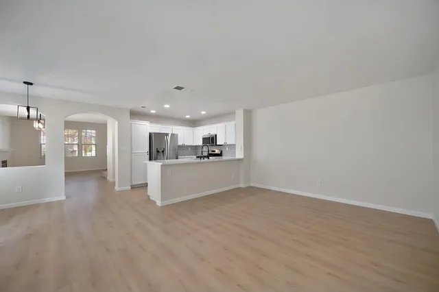a view of kitchen with kitchen island white cabinets and refrigerator