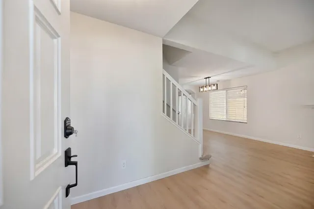 a view of hallway with stairs and wooden floor