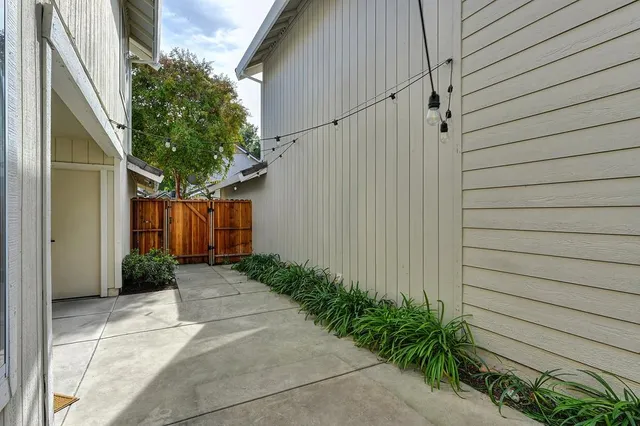 a backyard of a house with flower plants and outdoor seating