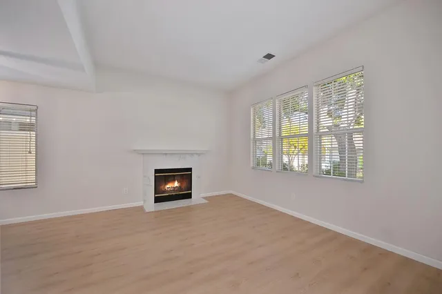 a view of an empty room with a window and a fireplace