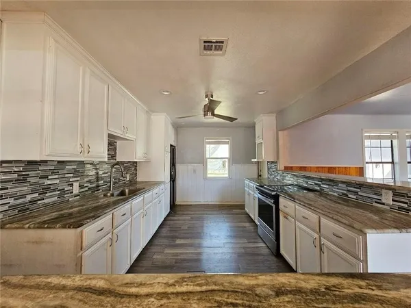 a kitchen with stainless steel appliances granite countertop a stove and a sink
