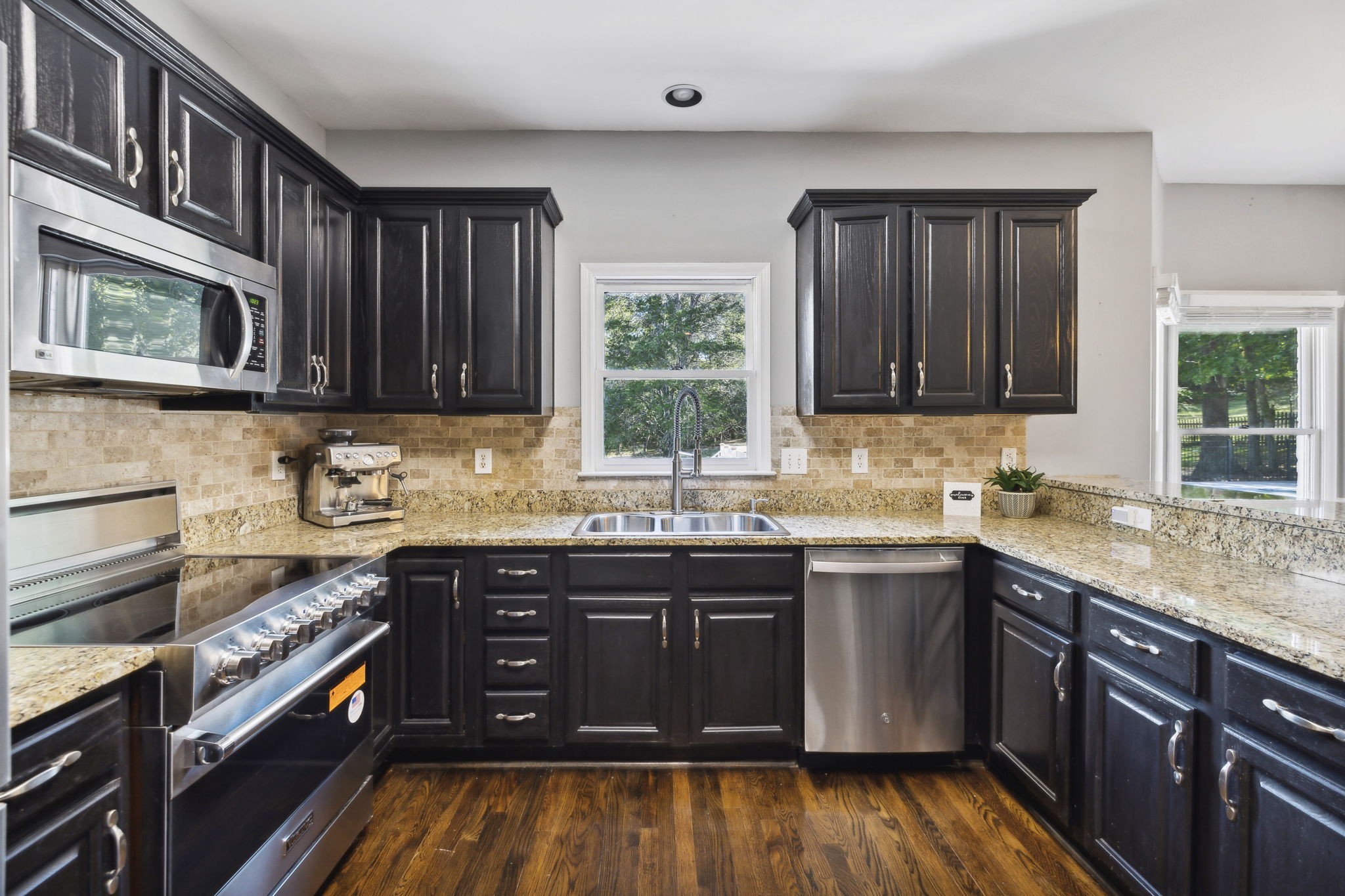 412 Martingale Drive Franklin, TN 37067 - Photo 14 of 56 a kitchen with stainless steel appliances granite countertop wooden cabinets a sink dishwasher a stove and a refrigerator with wooden floor