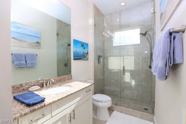 5717 Anegada Drive Naples, FL 34113 - Photo 13 of 37 a bathroom with a granite countertop sink toilet and shower