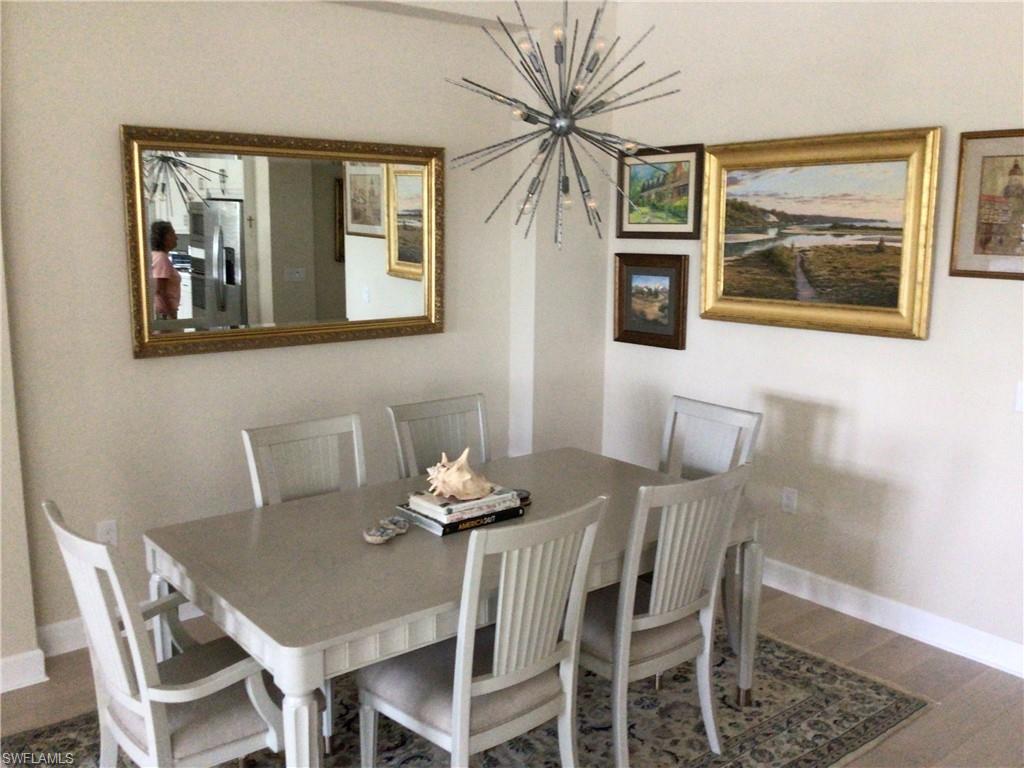 5717 Anegada Drive Naples, FL 34113 - Photo 18 of 37 a view of a dining room with furniture and wooden floor