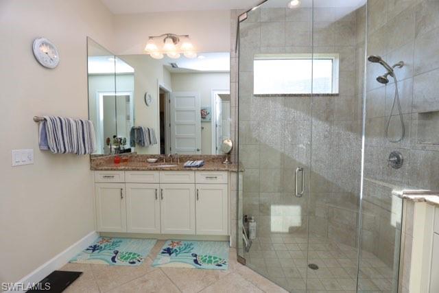 5717 Anegada Drive Naples, FL 34113 - Photo 21 of 37 a bathroom with a shower sink and mirror