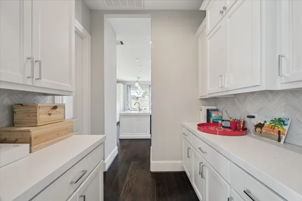 a kitchen with white cabinets and sink