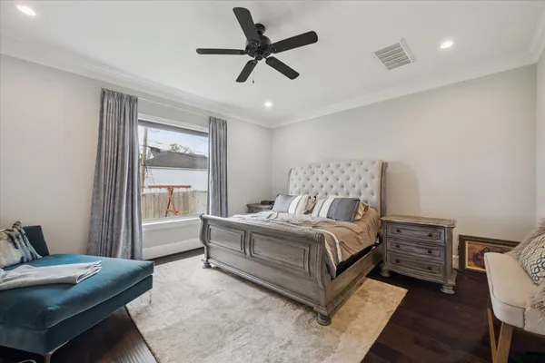 a bedroom with a bed a dresser and a window