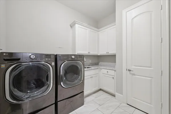 a utility room with sink dryer and washer