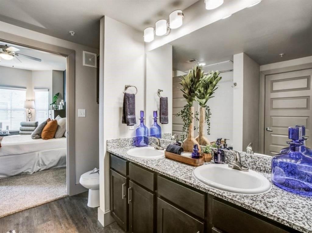 a en suite bathroom with a granite countertop sink and a mirror