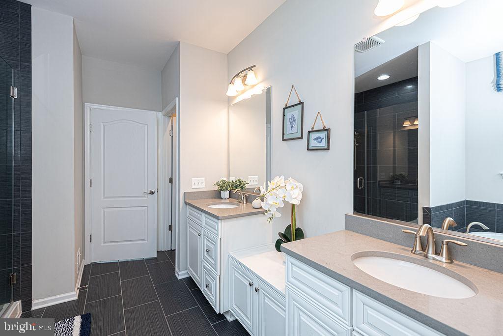 30134 Islander Beach Road Frankford, DE 19945 - Photo 30 of 73 a spacious bathroom with a double vanity sink and a mirror