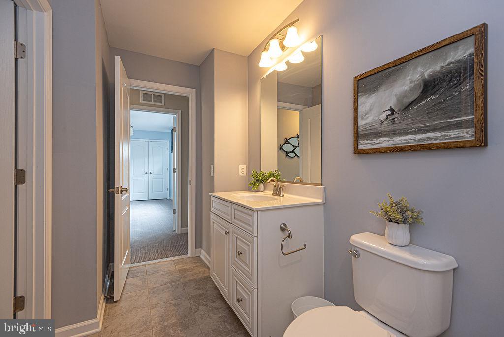 30134 Islander Beach Road Frankford, DE 19945 - Photo 48 of 73 a spacious bathroom with a toilet a sink and mirror