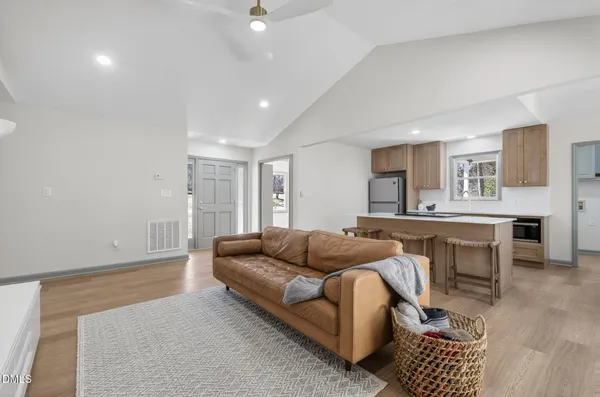 a living room with furniture a couch and a kitchen view