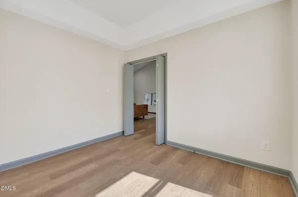 a view of a room with an empty space and wooden floor
