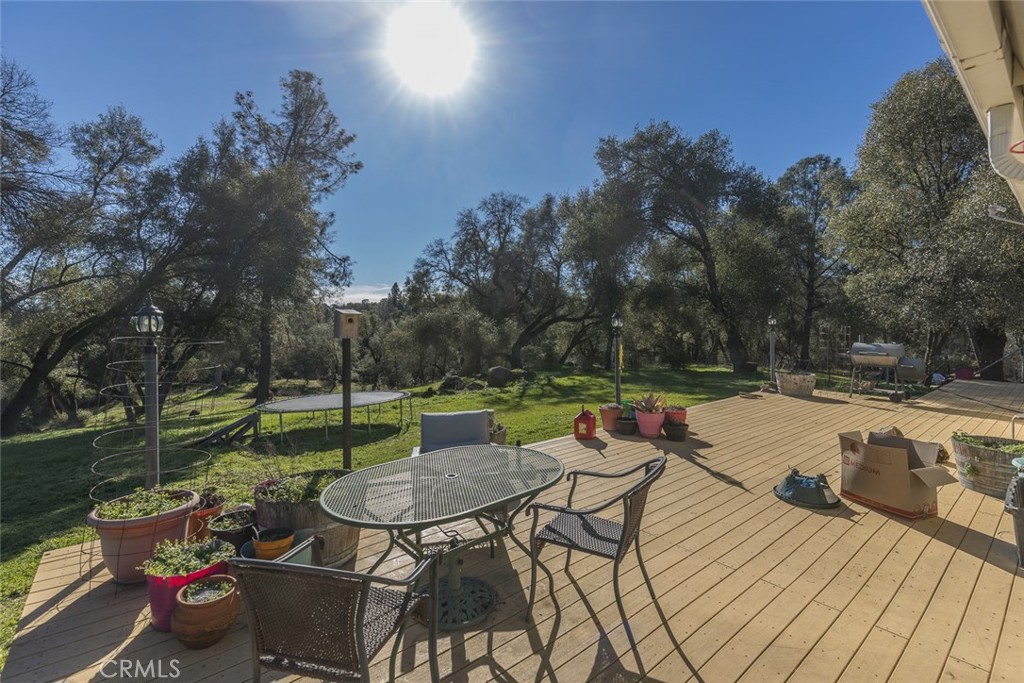 3977 Spring Court Mariposa, CA 95338 - Photo 48 of 72 a view of a patio with dining table and chairs with wooden floor and fence