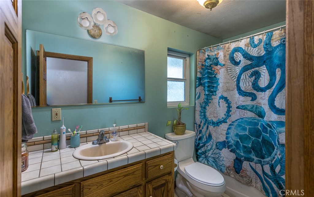 3977 Spring Court Mariposa, CA 95338 - Photo 71 of 72 a bathroom with a granite countertop sink mirror vanity and toilet