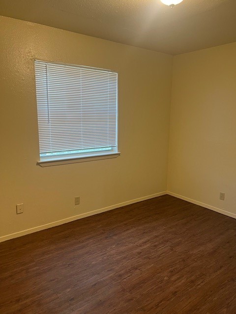 501 Hedgewood Drive, Unit C Georgetown, TX 78628 - Photo 12 of 17 a view of an empty room with wooden floor and a window
