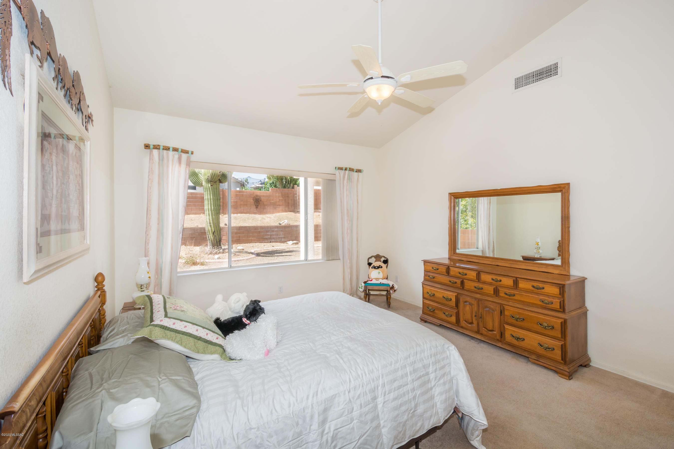 11341 Silver Pheasant Loop Oro Valley, AZ 85737 - Photo 14 of 41 a bedroom with a bed and a dresser next to a window