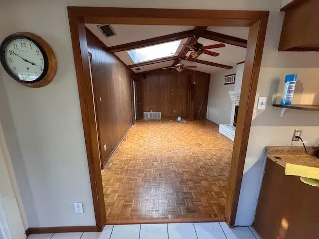 a view of a hallway with wooden floor and a fireplace
