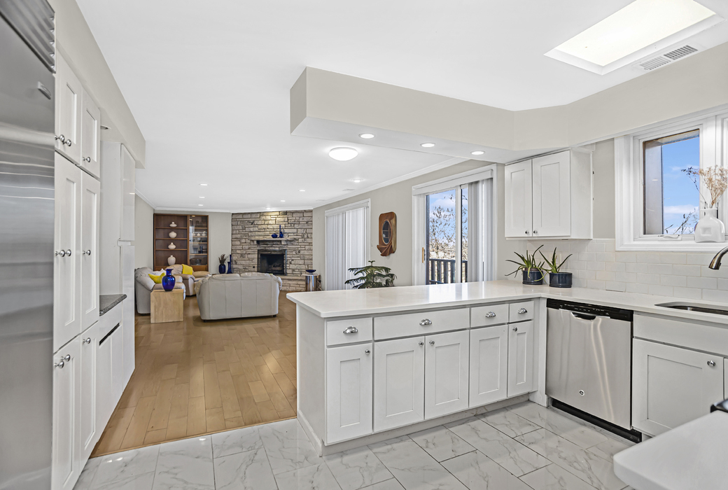 1125 Lake Cook Road, Unit 511 Northbrook, IL 60062 - Photo 8 of 18 a large white kitchen with cabinets a sink a window and stainless steel appliances
