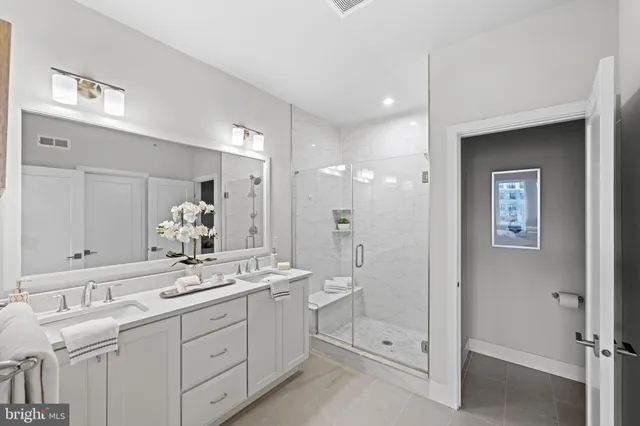 a bathroom with a double vanity sink mirror and shower