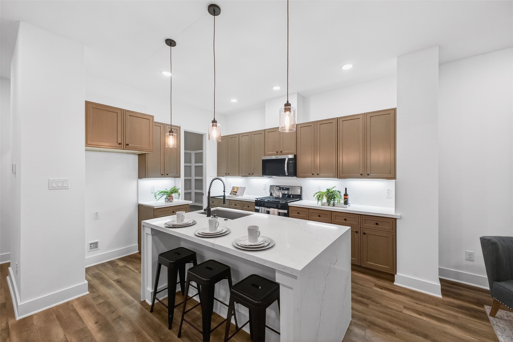 3003 A Delano Street Houston, TX 77004 - Photo 21 of 49 a kitchen with stainless steel appliances kitchen island a table chairs and a wooden floor