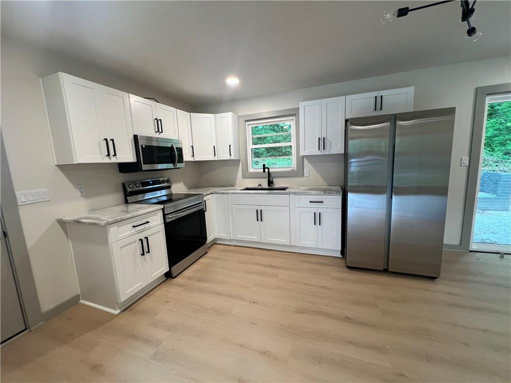 4396 Greenleaf Circle Southwest Atlanta, GA 30331 - Photo 5 of 18 a kitchen with white cabinets stainless steel appliances and a window