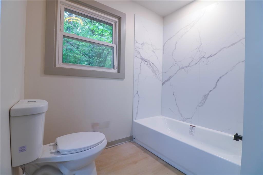 4396 Greenleaf Circle Southwest Atlanta, GA 30331 - Photo 10 of 18 a white toilet sitting next to a bath tub