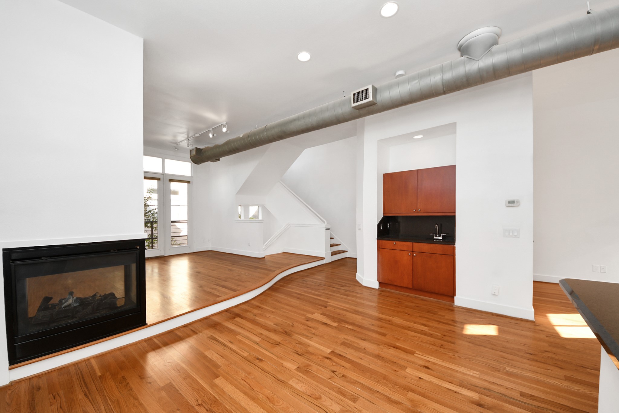 2436 Bissonnet Street, Unit 8 Houston, TX 77005 - Photo 18 of 42 a view of a living room with wooden floor and a fireplace