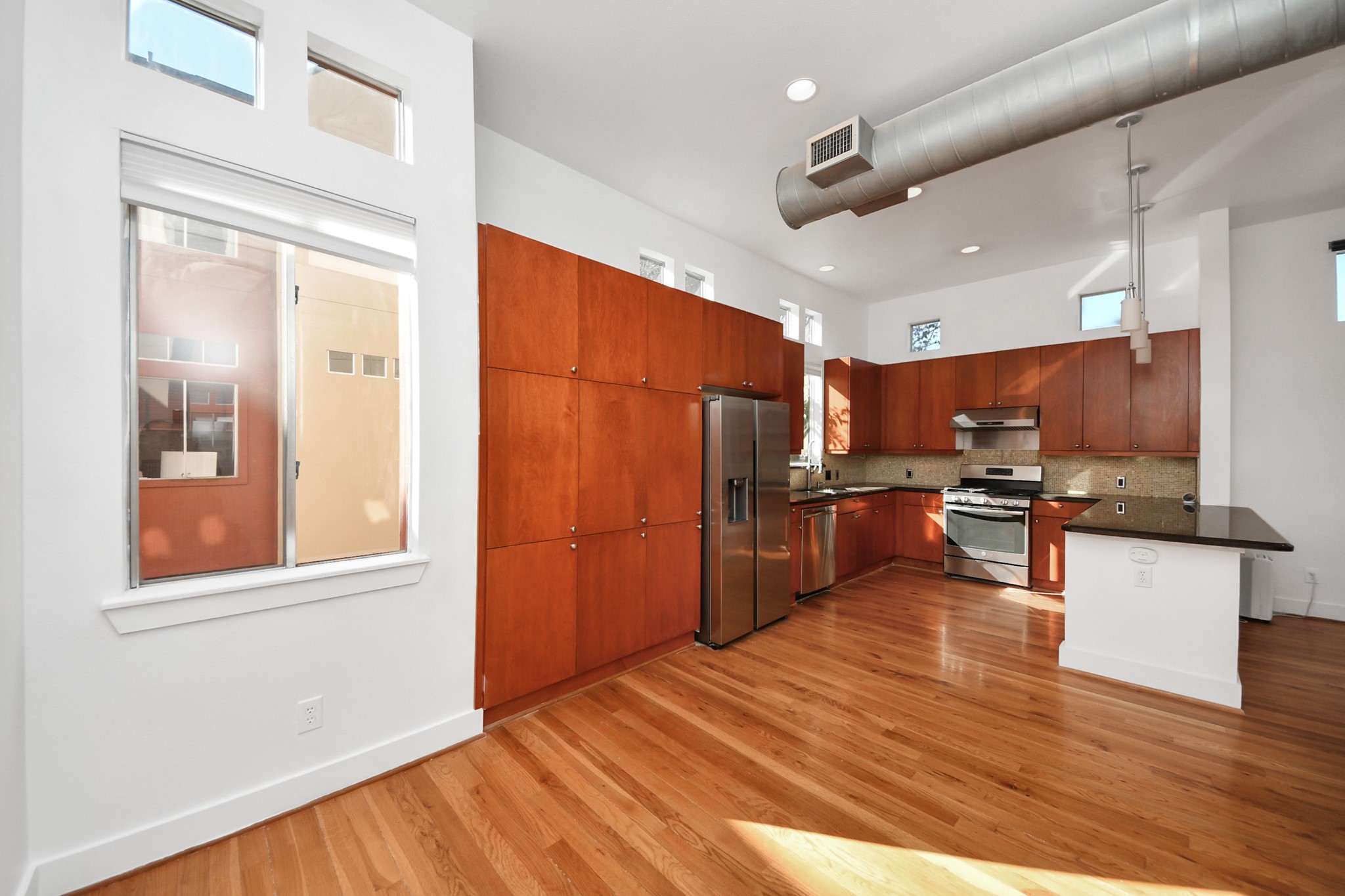 2436 Bissonnet Street, Unit 8 Houston, TX 77005 - Photo 20 of 42 a kitchen with stainless steel appliances wooden floor and large windows