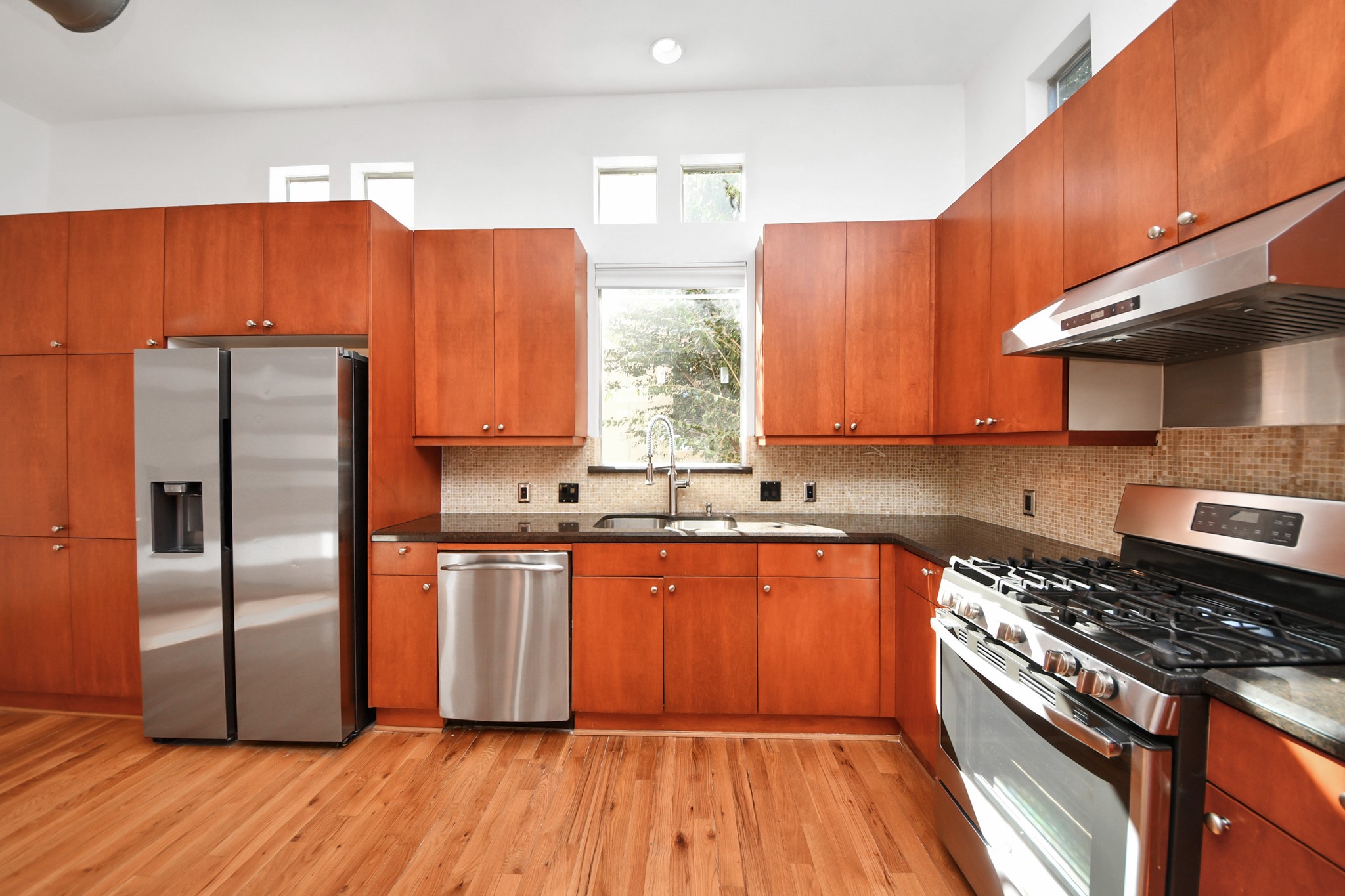2436 Bissonnet Street, Unit 8 Houston, TX 77005 - Photo 24 of 42 a kitchen with stainless steel appliances a refrigerator a sink and wooden cabinets