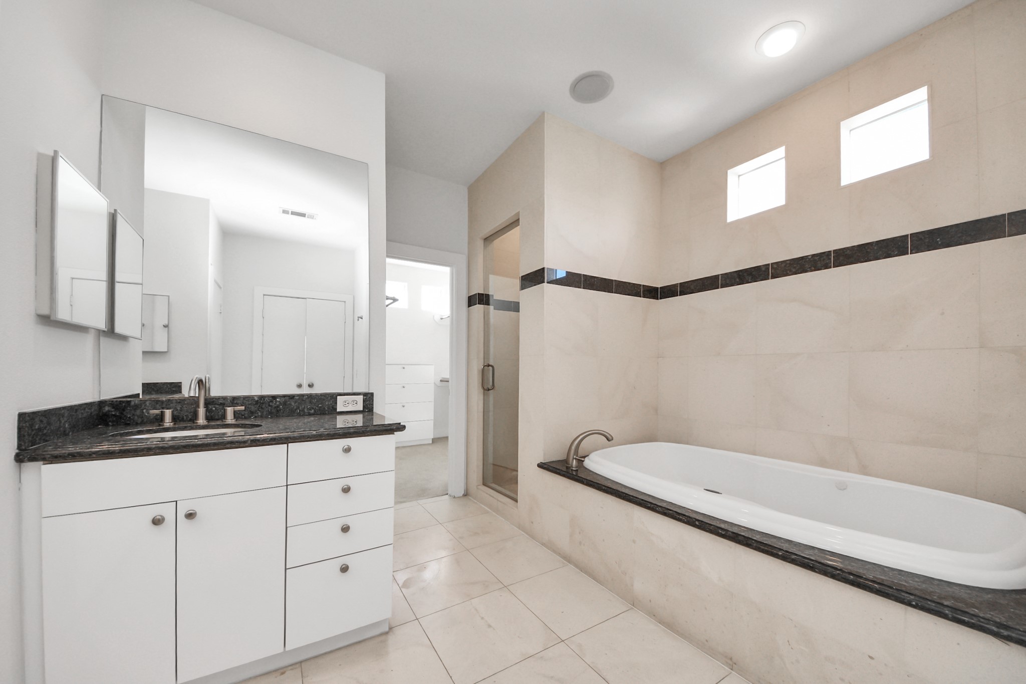 2436 Bissonnet Street, Unit 8 Houston, TX 77005 - Photo 30 of 42 a bathroom with a granite countertop sink a mirror and a bathtub