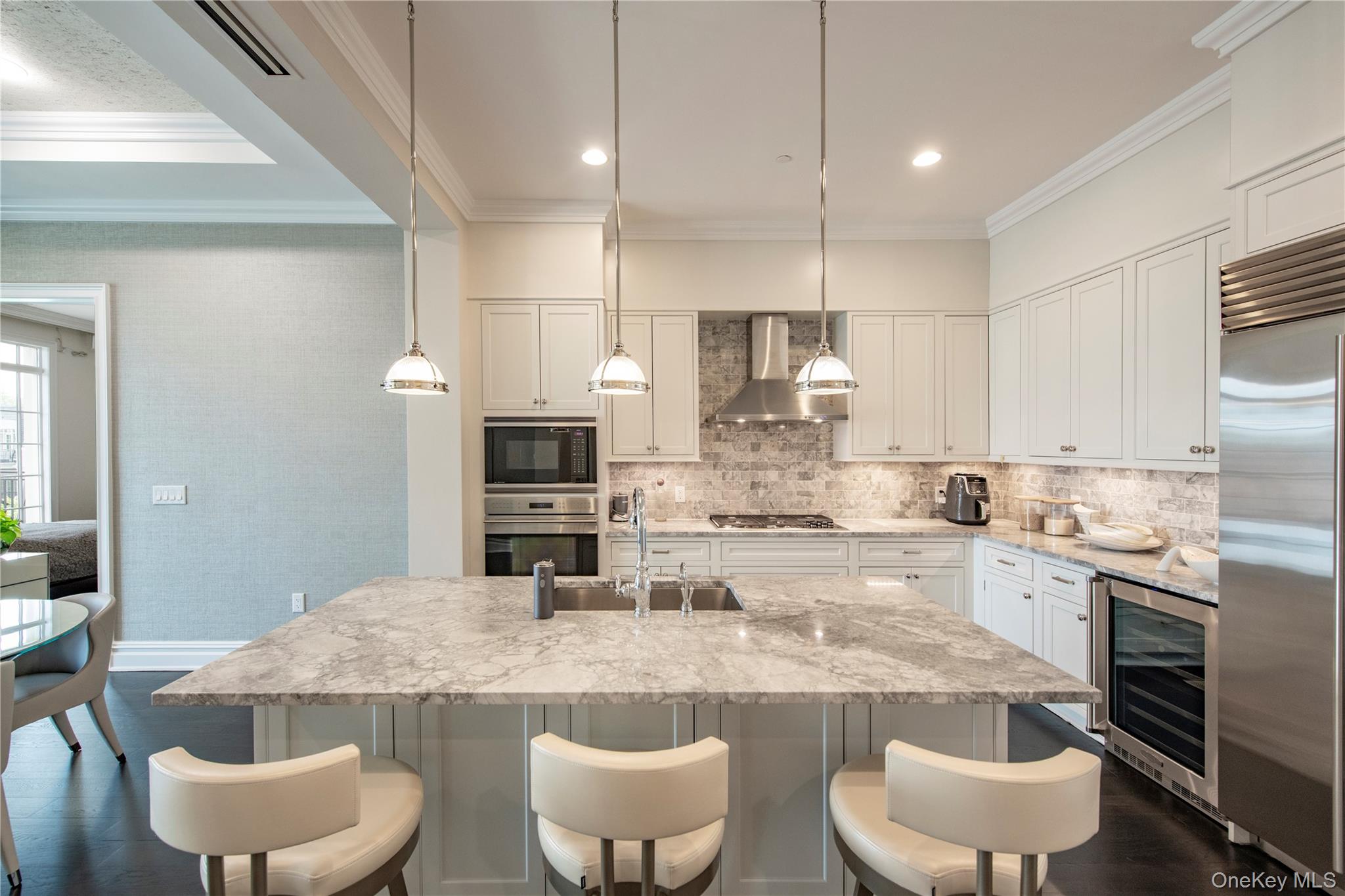 a kitchen with stainless steel appliances kitchen island granite countertop a dining table and chairs