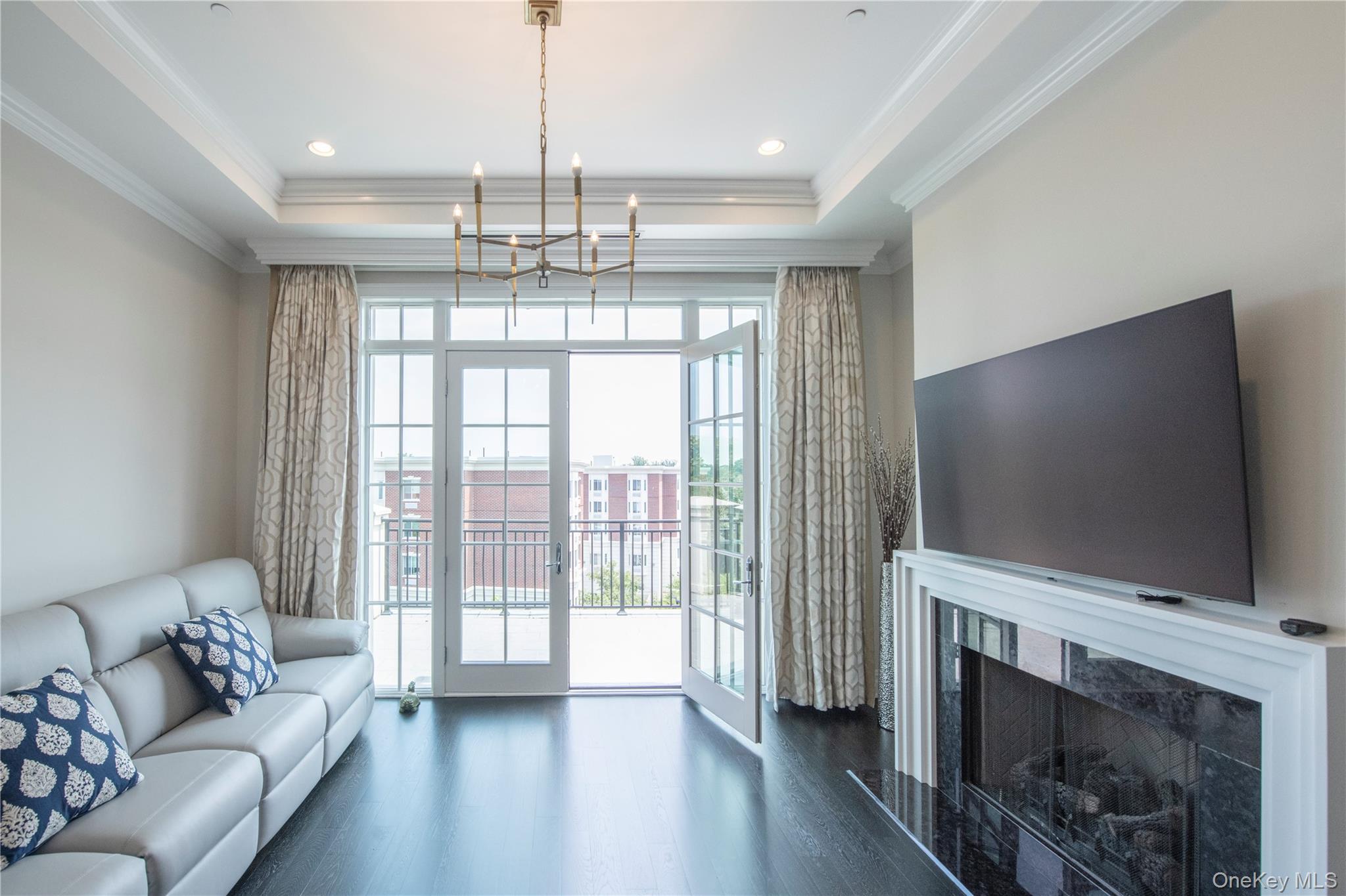 1000 Royal Court, Unit 1306 North Hills, NY 11040 - Photo 5 of 33 a living room with furniture and a flat screen tv