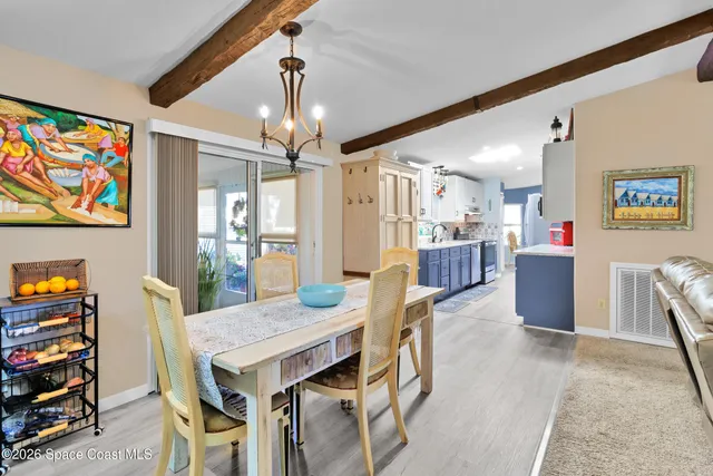 a view of a dining room with furniture and a chandelier